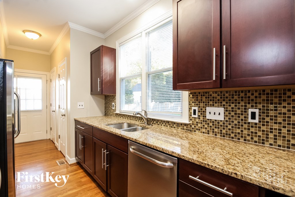 A kitchen with brown cabinets and a granite countertop.
