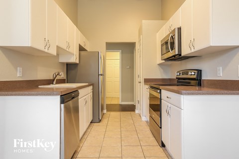 a kitchen with white cabinets and stainless steel appliances