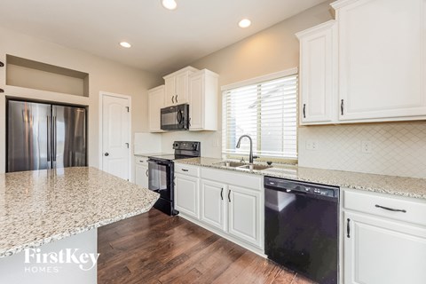 a kitchen with white cabinets and a counter top and a sink