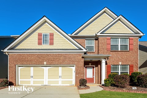 a brick house with two peaked roofs and a white garage door