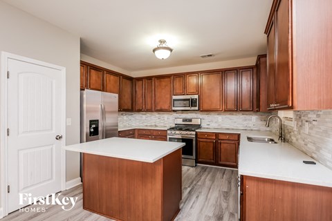 a kitchen with wooden cabinets and a white counter top