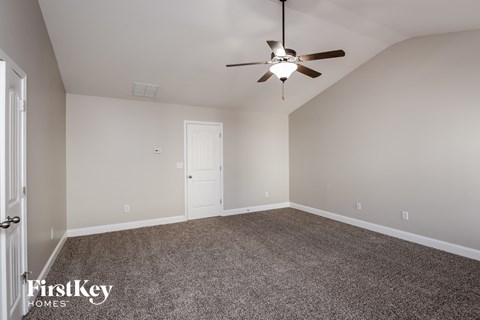 a bedroom with carpet and a ceiling fan