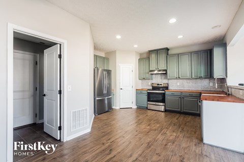 A kitchen with wooden floors and a white refrigerator.