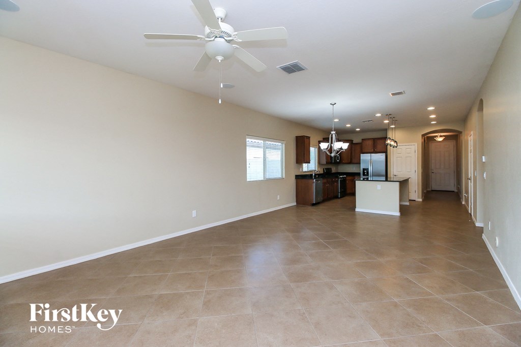 a large living room and kitchen with a ceiling fan