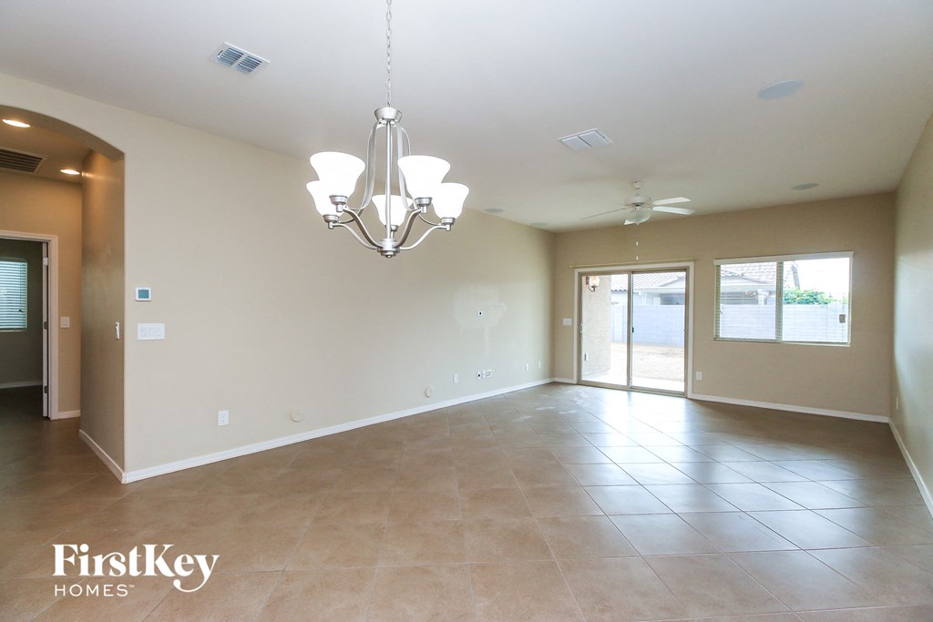 an empty living room and dining room with a chandelier