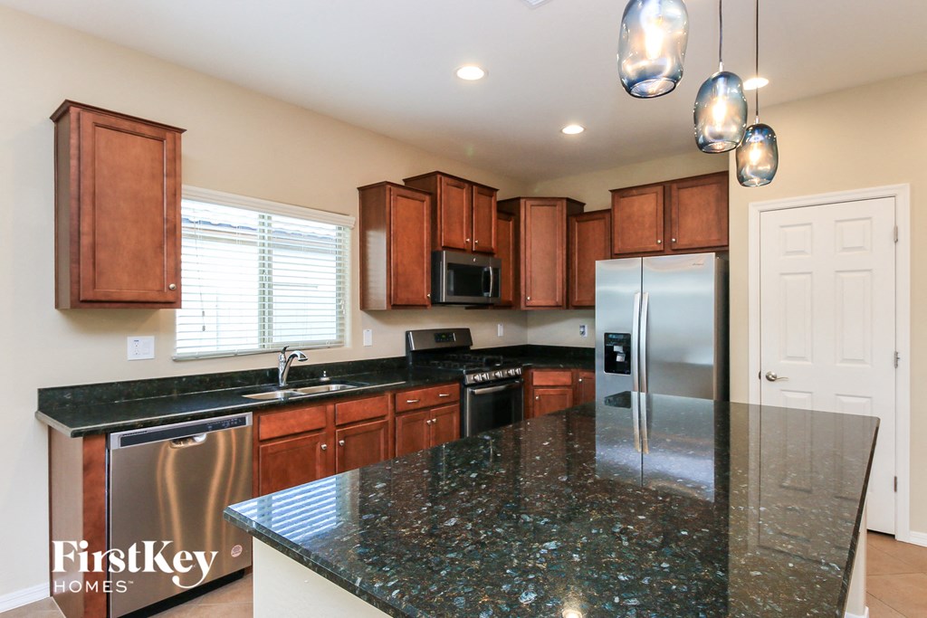a kitchen with granite counter tops and wooden cabinets