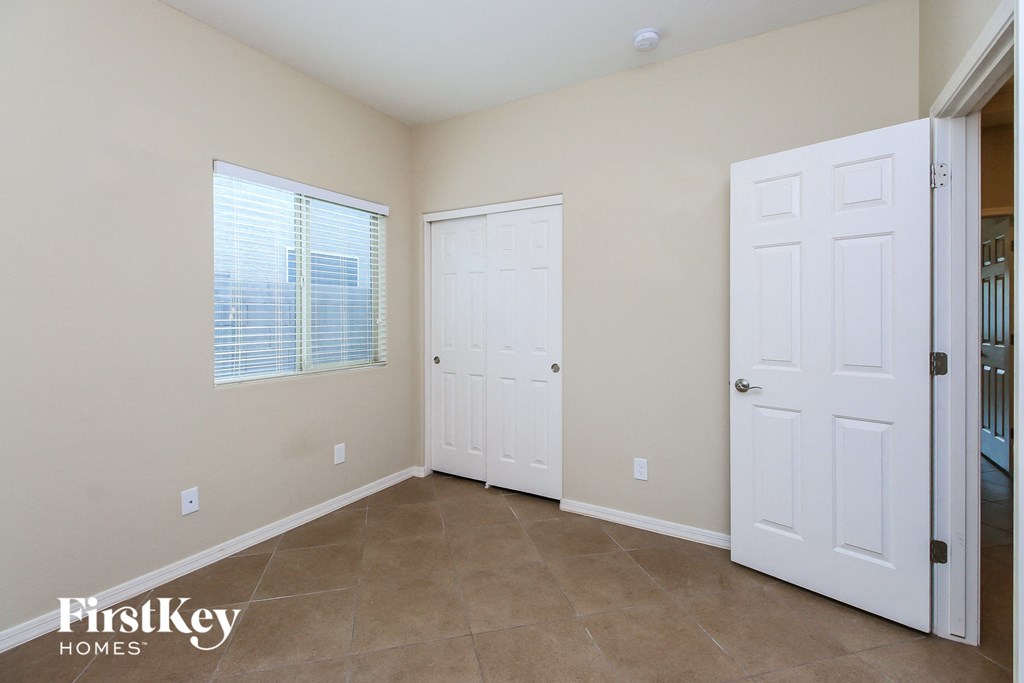 a bedroom with two doors and a door to a closet