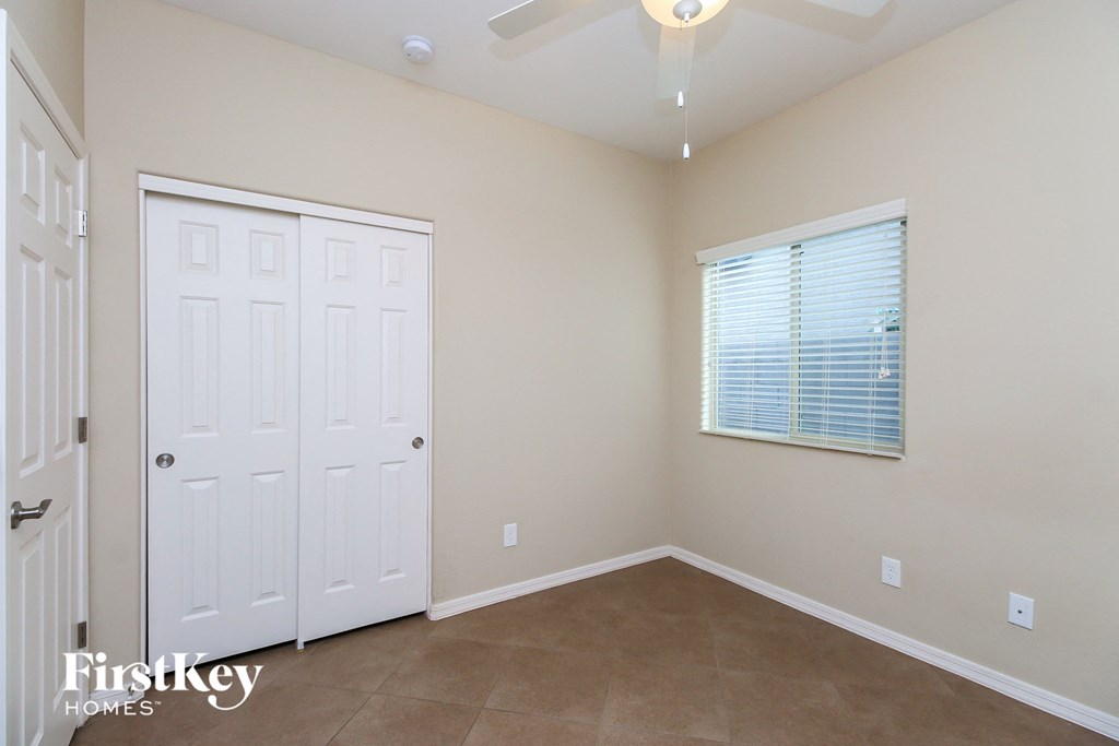 a bedroom with a ceiling fan and a closet