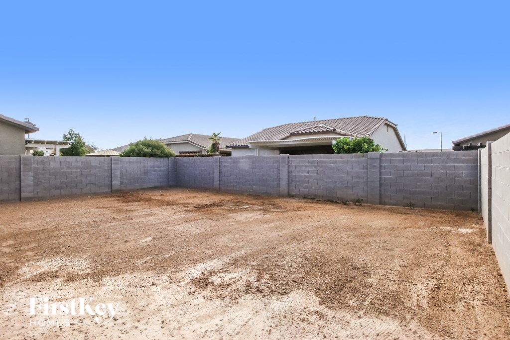 a backyard with a retaining wall and a house