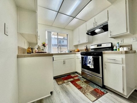 A kitchen with white cabinets and a stainless steel oven.