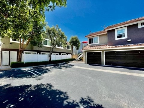 A sunny day in a quiet residential street with houses on both sides and a clear blue sky.