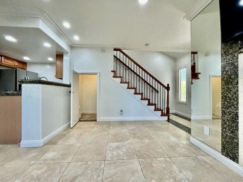 A spacious living room with a staircase leading to the upper floor.