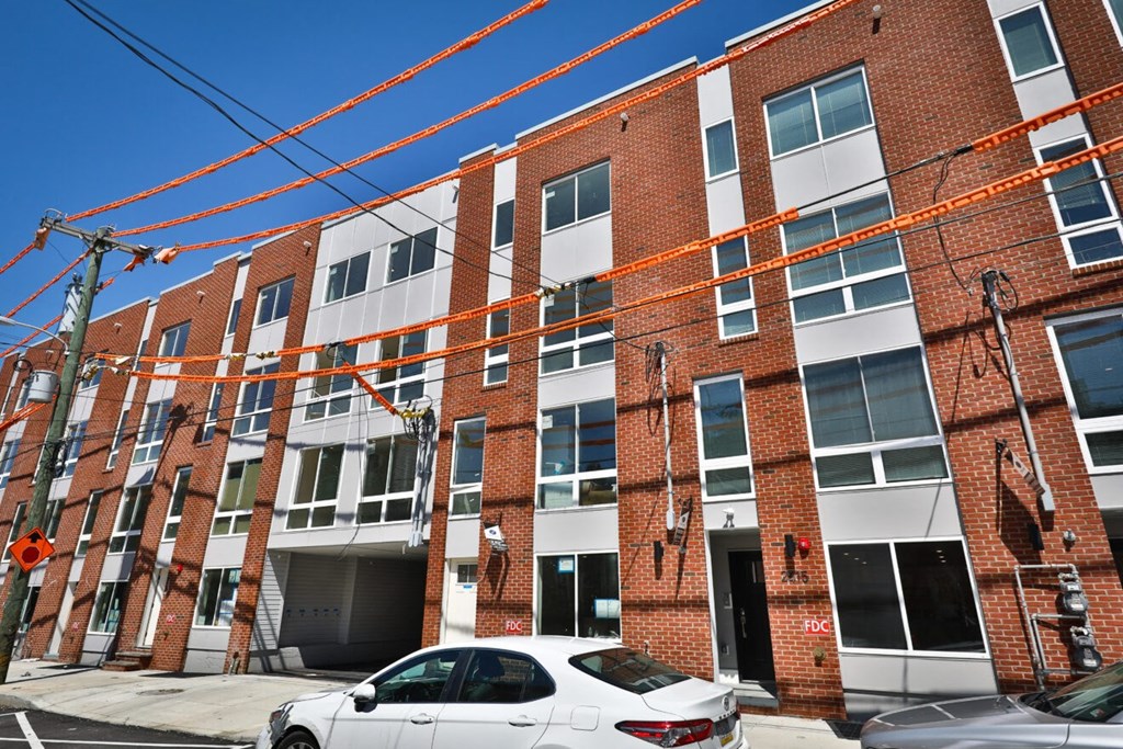 an apartment building with a white car parked in front of it
