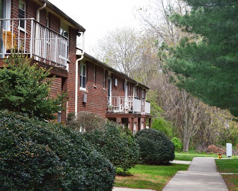a sidewalk in front of a brick apartment building