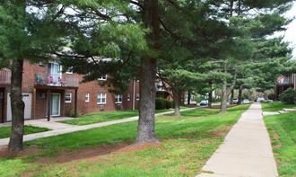 a sidewalk in front of a brick apartment building