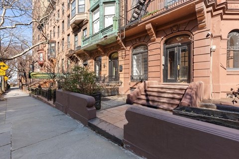 a brown building with a sidewalk in front of it