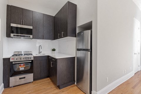 a kitchen with stainless steel appliances and black cabinets