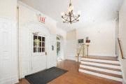 a large white room with a staircase and a chandelier