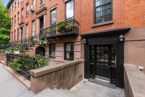 the front of a brick building with a black door