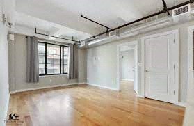 an empty living room with white walls and wood floors