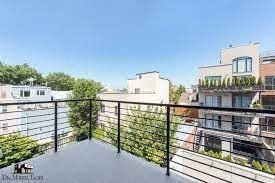 a balcony with a fence and a view of the city