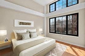 a bedroom with a bed and a large window