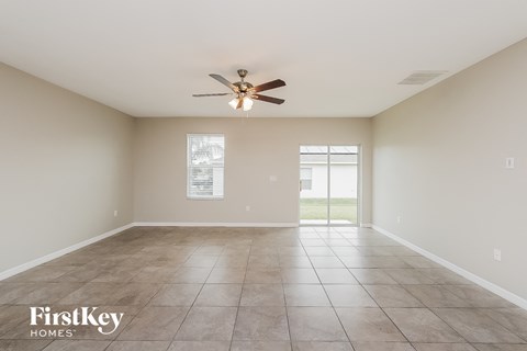 A spacious room with a ceiling fan and tiled floor.