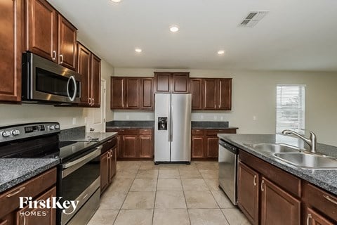 A kitchen with brown cabinets and a stainless steel refrigerator.