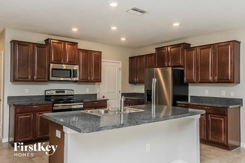 A kitchen with brown cabinets and a stainless steel refrigerator.