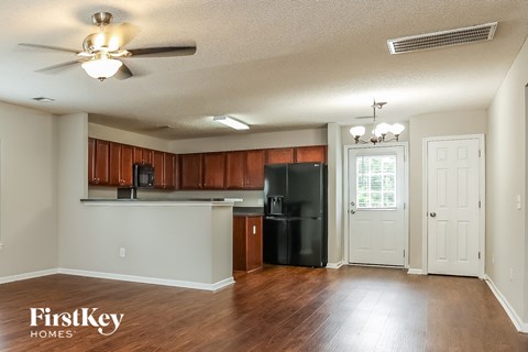 A kitchen with wooden cabinets and a black refrigerator.