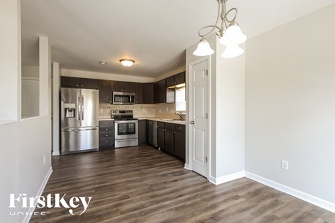 A kitchen with wooden floors and a FirstKey logo.