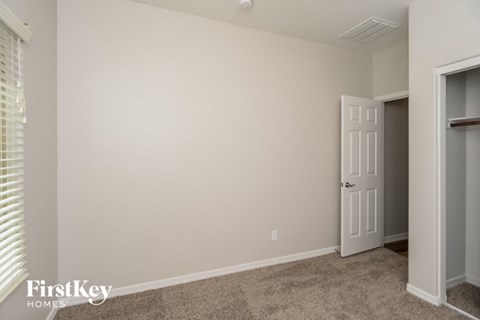 a bedroom with a white wall and a door to a closet