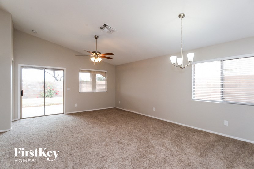 A spacious room with a ceiling fan and carpeted floor.