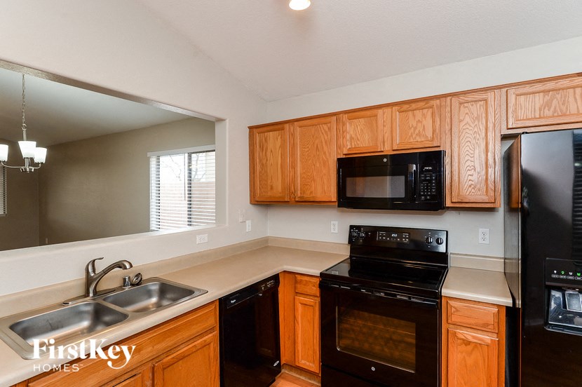 A kitchen with wooden cabinets and a black stove top oven.