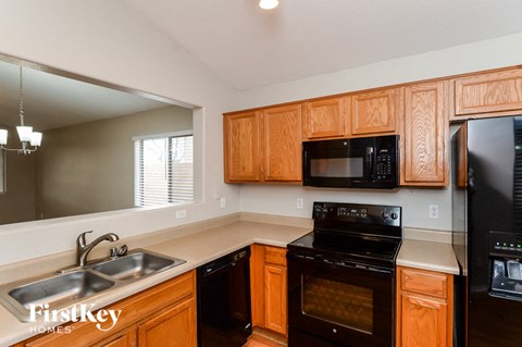 A kitchen with wooden cabinets and a black stove top oven.