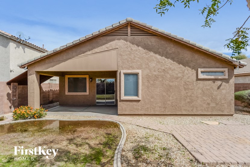 A house with a brown stucco exterior and a brick patio.