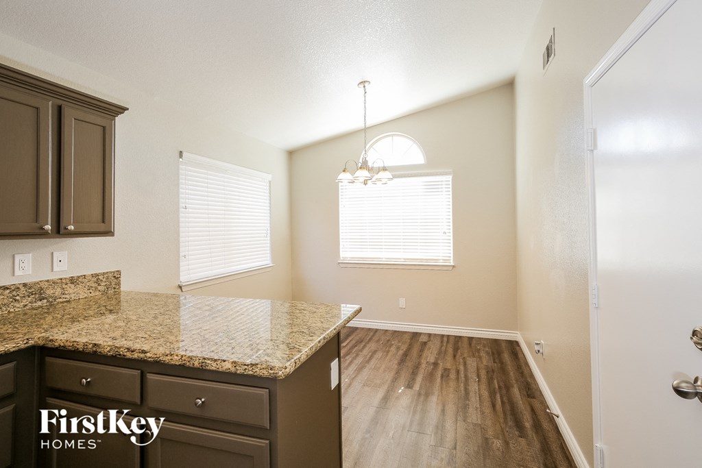 an empty kitchen with a counter top and a window
