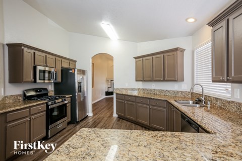 the kitchen has granite counter tops and stainless steel appliances