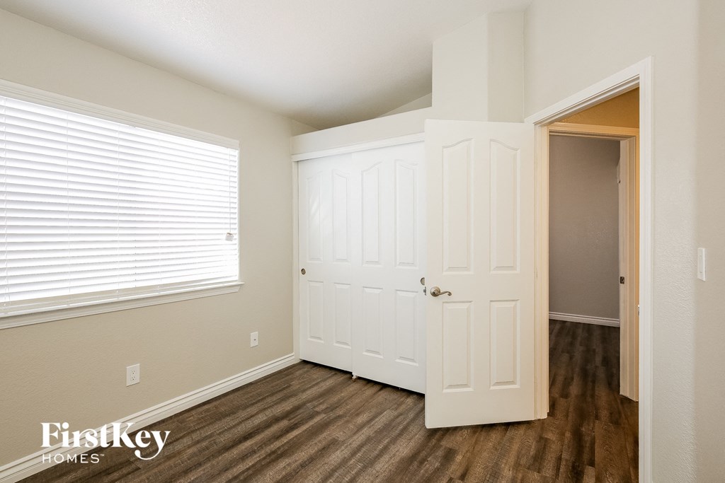 a bedroom with a door and a closet and a window