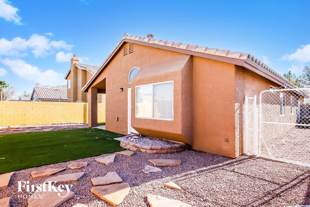 a backyard with a house and a chain link fence
