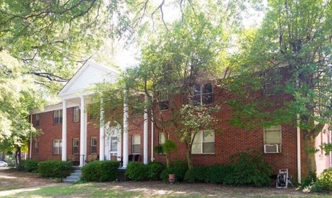a red brick house with trees in front of it