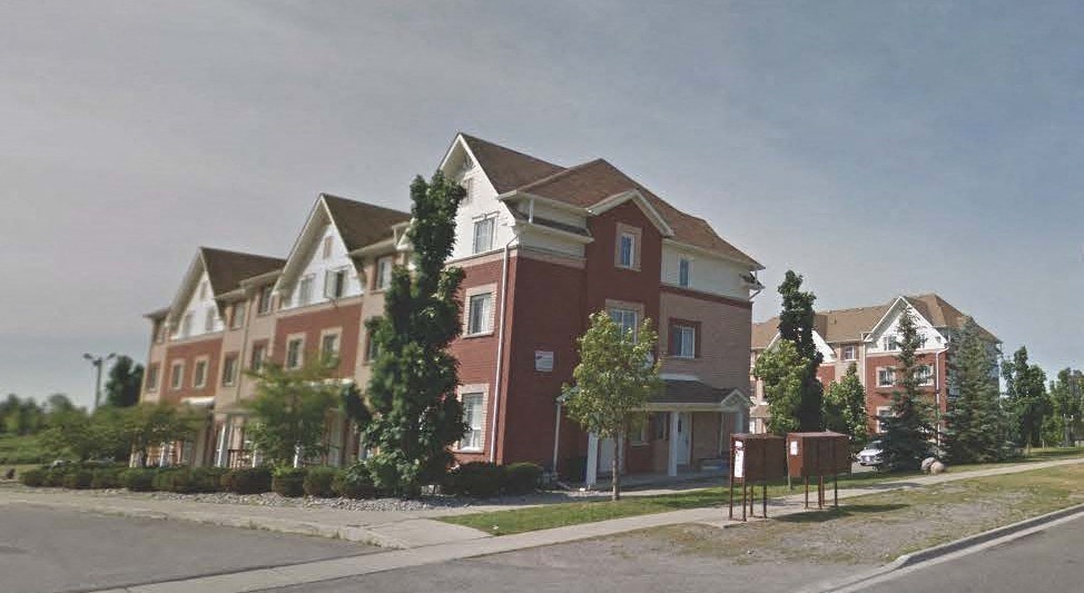 a red brick house on the side of a street