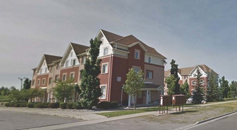 a red brick house on the side of a street