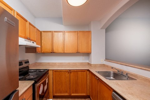 a kitchen with wooden cabinets and a sink and a stove
