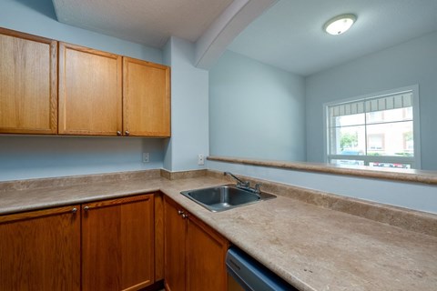 an empty kitchen with a sink and counter top