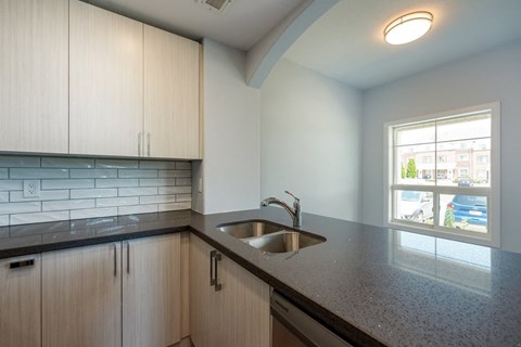 an empty kitchen with white cabinets and a sink