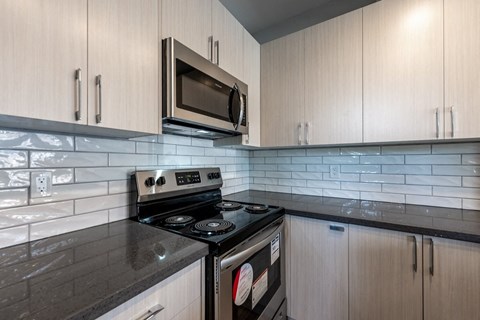 a kitchen with white cabinets and a stove and a microwave