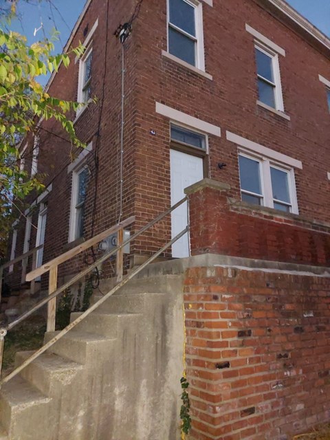 A red brick building with a white door and windows.