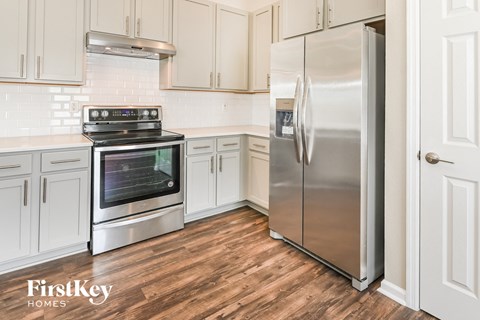 a kitchen with white cabinets and stainless steel appliances