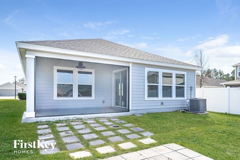 the exterior of a small blue house with a yard and grass